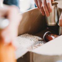 close up photo of volunteers preparing donation boxes with food at the food and clothes bank - food stock pictures, royalty-free photos & images