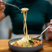 close up shot of a woman eating creamy salted egg pasta - food stock pictures, royalty-free photos & images
