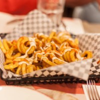closeup of a platter of french fries on a restaurant table - junk food stock pictures, royalty-free photos & images