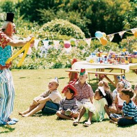 clown entertaining children sitting on the grass at a birthday party - garden decoration stock pictures, royalty-free photos & images