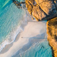 coastline aerial photograph of aquamarine ocean and man walking along white sandbar beach - travel stock pictures, royalty-free photos & images