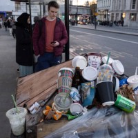 Coffee and soft drinks cups from some of the major take away food and drinks companies piled up on top of an overflowing street rubbish bin on 15th...