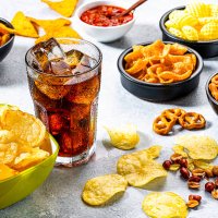 cola soda glass and salty snacks shot on gray table - junk food stock pictures, royalty-free photos & images