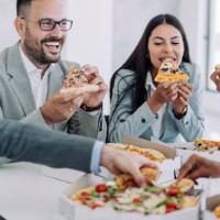 colleagues having lunch break together in the office. - junk food stock pictures, royalty-free photos & images