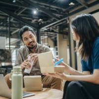 colleagues working while having lunch in the office - junk food stock pictures, royalty-free photos & images