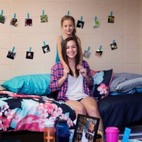 college student smiling with sister in dormitory room - home decoration stock pictures, royalty-free photos & images