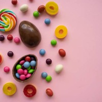 colorful round lollipop, chocolate easter eggs, candies and jellies over pink background. summer background. sweet food. - junk food stock pictures, royalty-free photos & images