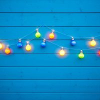 colorful string lights for party decoration at a blue painted wooden wall - garden decoration stock pictures, royalty-free photos & images