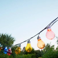 colorful string lights for party decoration in garden against sky - garden decoration stockfoto's en -beelden