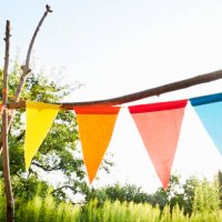 colourful bunting flags/ pennant chain for party decoration in a garden against sky - garden decoration stock pictures, royalty-free photos & images