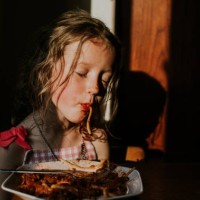 comical image of a sleepy little girl sucking spaghetti - food stock pictures, royalty-free photos & images