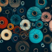composition of sewing spools with colorful vibrant threads from above - fashion stock pictures, royalty-free photos & images
