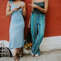 conceptual image of two fashionable females against a red wall in positano, italy - fashion stock pictures, royalty-free photos & images