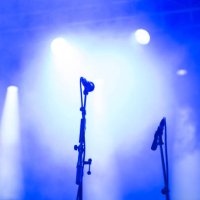 concert microphones on a concert stage under blue and white spotlights - concert stock pictures, royalty-free photos & images