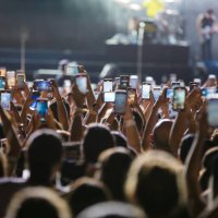 Concertgoers record videos and take photos with their smartphones as Jonas Brothers perform live on stage during a concert on April 16, 2024 in Sao...