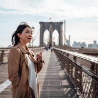 confident businesswoman using smart phone on brooklyn bridge, new york - travel stock pictures, royalty-free photos & images
