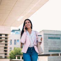 confident businesswoman with takeaway coffee speaking on smartphone on street - junk food stock pictures, royalty-free photos & images