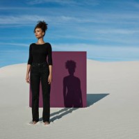 confident young fashion model standing against purple placard at white desert - fashion stock pictures, royalty-free photos & images