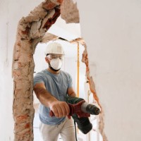 construction worker demolishing a brick wall - home decoration stock pictures, royalty-free photos & images