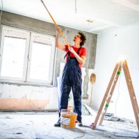 construction worker painting apartment ceiling with paint roller - home decoration stock pictures, royalty-free photos & images