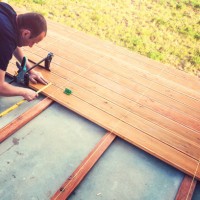 construction worker screwing down wood deck with battery power screw gun or drill. - home decoration stock pictures, royalty-free photos & images