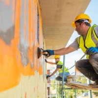 construction workers applying plaster on building facade - home decoration stockfoto's en -beelden