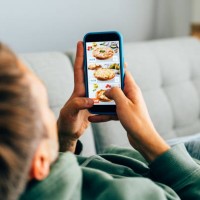 contactless food delivery. mobile app on phone screen. person holds smartphone in hand - food stock pictures, royalty-free photos & images