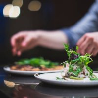 cook preparing many plates in a restaurant kitchen. catering. caterer - food stock pictures, royalty-free photos & images