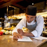 cook working at a restaurant and looking at a recipe online - food stock pictures, royalty-free photos & images
