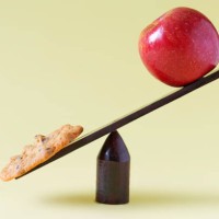 cookie and apple on scale - junk food stock pictures, royalty-free photos & images