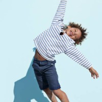 cool and cute boy jumping on beach with backdrop - fashion stock-fotos und bilder