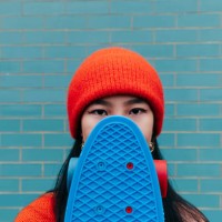 cool asian woman hiding her face with a skateboard - fashion stock pictures, royalty-free photos & images