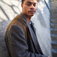 cool looking man looking off camera leaning against a wall - fashion stock pictures, royalty-free photos & images