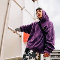 cool young man wearing hooded shirt standing on metallic ladder against sky - fashion stock pictures, royalty-free photos & images