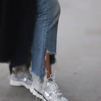 Corina Mihaila Larpin seen wearing a black and white striped long Monse Jaket, light blue denim Jeans from R13, and white, silver and black Nike...