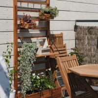 cosy space with garden furniture and plants on the rooftop terrace in sunny summer day - garden decoration stockfoto's en -beelden