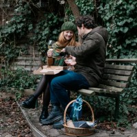 coupe who met online sharing pizza on park bench - junk food stock pictures, royalty-free photos & images