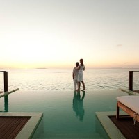 couple admirant le coucher du soleil au bord de la piscine - travel photos et images de collection