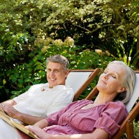 couple assis sur des chaises longues sur le jardin - garden decoration photos et images de collection