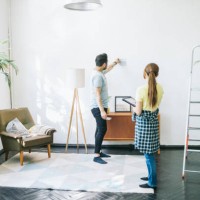 couple choosing the right color for their walls - home decoration stock pictures, royalty-free photos & images