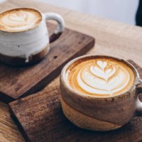 couple cup of latte coffee on wooden table. - coffee stockfoto's en -beelden