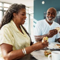 couple de personnes âgées afro-américaines prenant leur petit-déjeuner dans une chambre d’hôtel pendant leurs vacances - food photos et images de collection