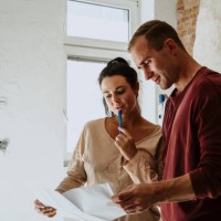couple discussing over floor plan in room while renovating home - home decoration stock pictures, royalty-free photos & images