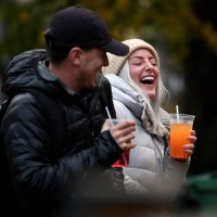 Couple drink from takeaway glasses outside a pub in the Grassmarket following last orders at 6pm on October 9, 2020 in Edinburgh, Scotland. Pubs and...