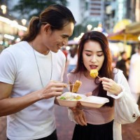 couple eating dumplings at a night market - food stock pictures, royalty-free photos & images