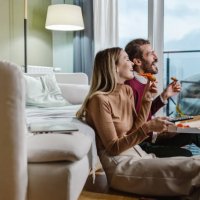 couple eating pizza and watching tv - junk food stock pictures, royalty-free photos & images