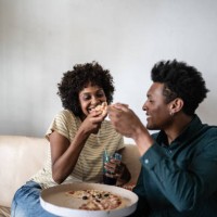 couple eating pizza together at home - junk food stock pictures, royalty-free photos & images