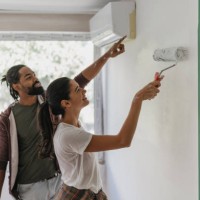 couple enthusiastically painting together indoors - home decoration stock pictures, royalty-free photos & images