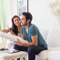 couple examining blueprints in living room - home decoration stock pictures, royalty-free photos & images