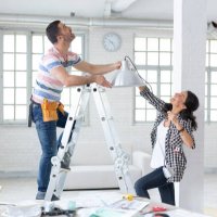 couple hanging a lamp in new apartment - home decoration stock pictures, royalty-free photos & images